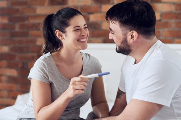 Couple happy with pregnancy test stick.