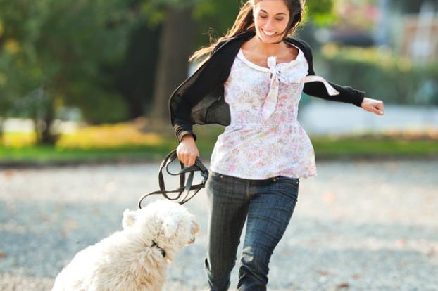 Running with dog on a leash outside.