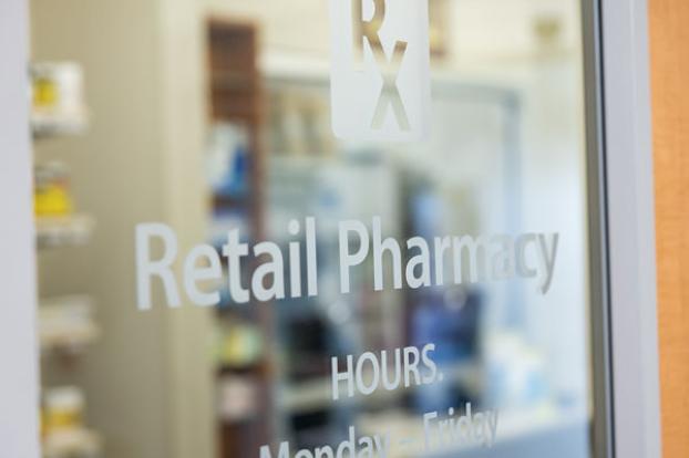 Entrance of Woman's Hospital Retail Pharmacy with glass doors and signage.