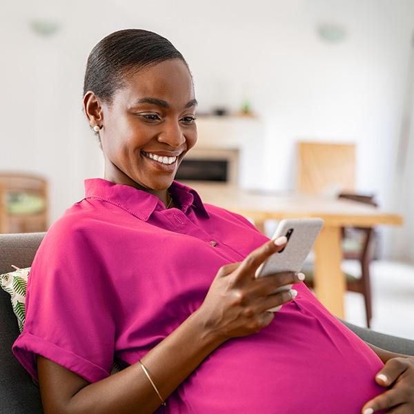 Pregnant woman reading on her phone.