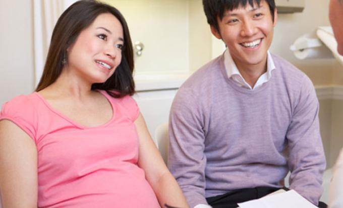 Pregnant couple talking with provider