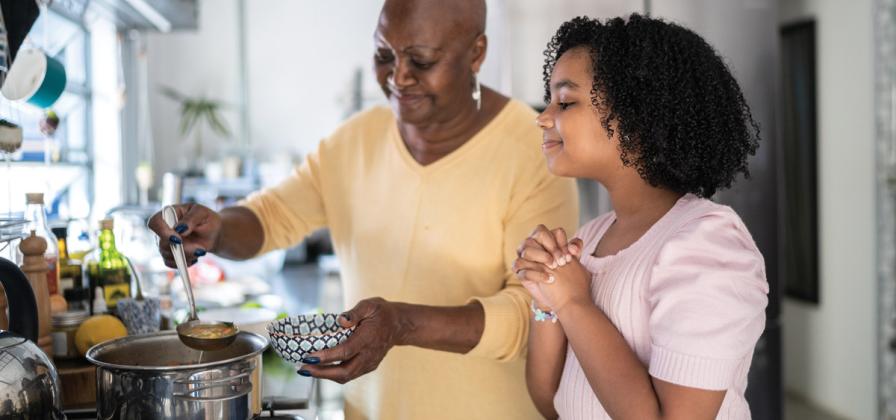 Adult serving soup to child