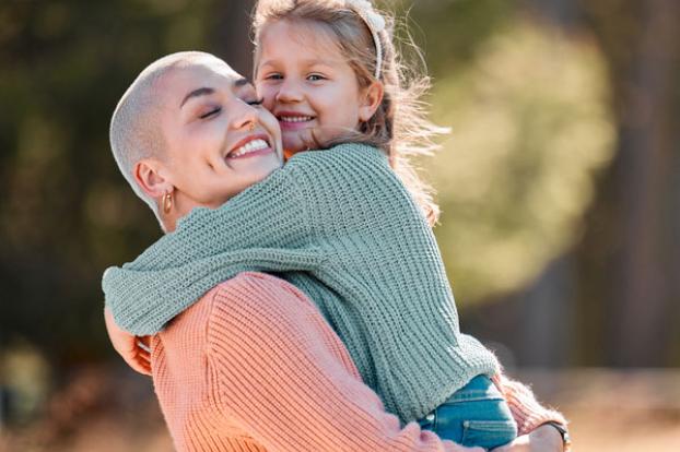 Bald and hugging child in sweater.