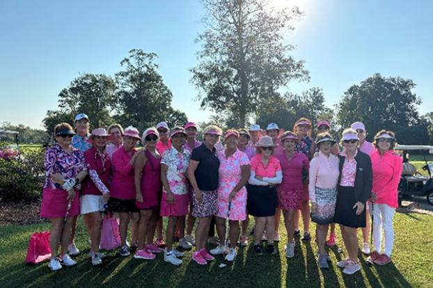 Women in pink pose on a golf course